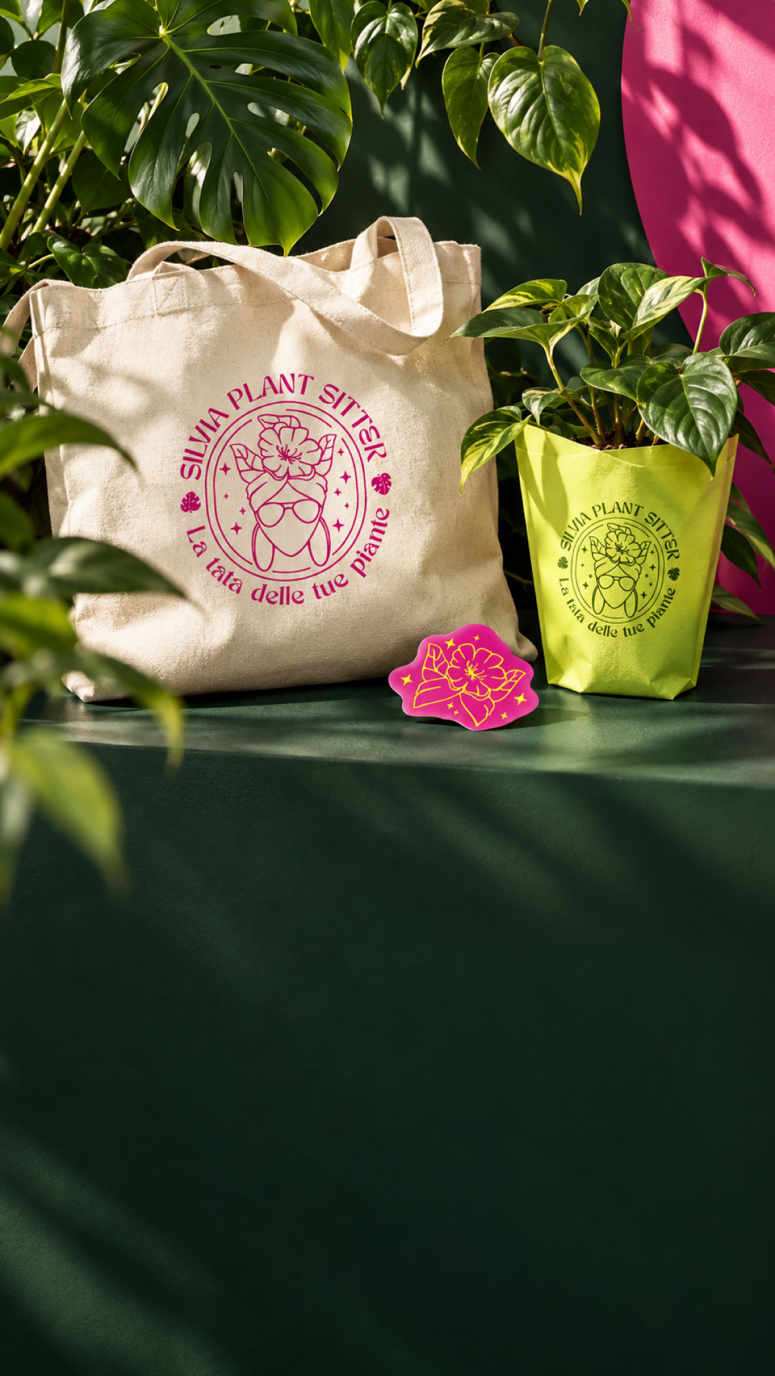 Copertina verticale Silvia Plant Sitter con shopper, piante, marchio fucsia e applicazione lime, sopra una superficie verde scuro