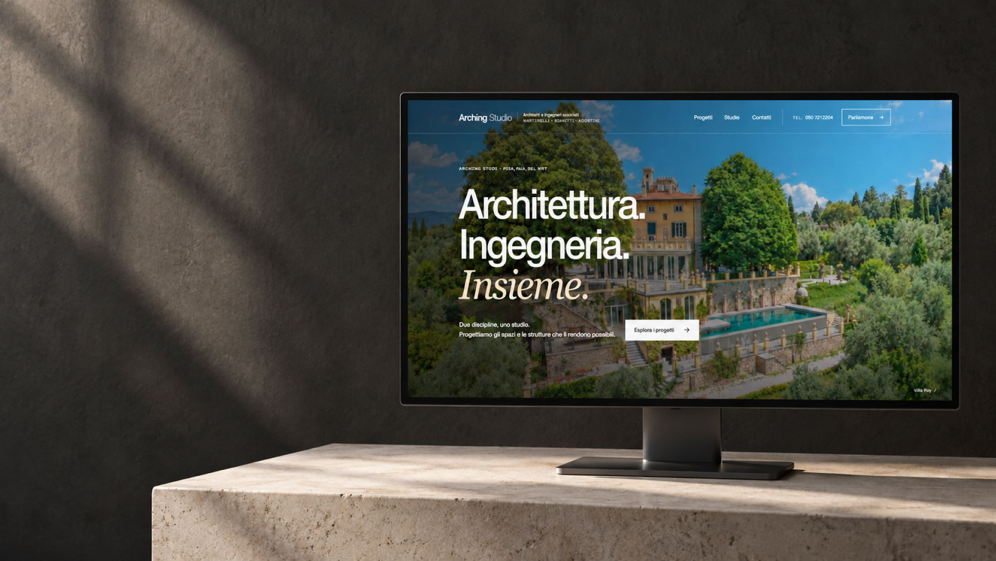 Sito web Arching Studio su monitor, con Villa Rey in apertura e ambientazione in pietra chiara e grafite.